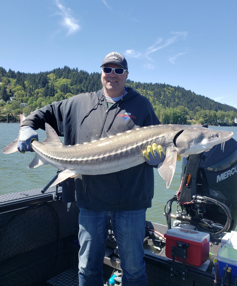 man posing with a caught sturgeon